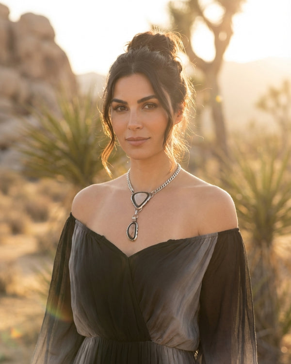 Woman standing in the desert wearing a statement necklace of Willow Creek Jasper