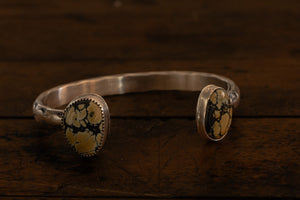 Silver cuff with two yellow and black stones
