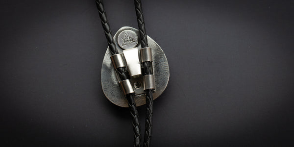 Back view of #8 bolo tie with rainbow stamped design on backplate