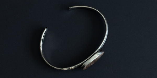 Side view of a handmade sterling silver cuff with an Imperial Jasper stone set in a plain bezel