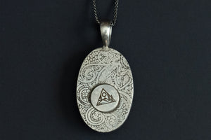 back view of Handmade White Buffalo stone necklace set in sterling silver with a paisley pattern stamped on the back