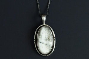 Handmade White Buffalo stone necklace set in sterling silver with natural black and white pattern