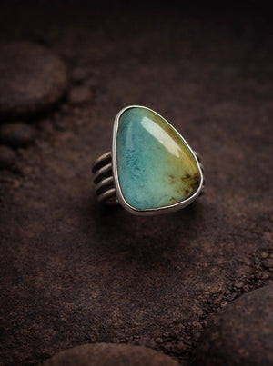 Blackjack turquoise stone set in .925 sterling silver setting with a plain bezel and a wide, pattern wire ring band