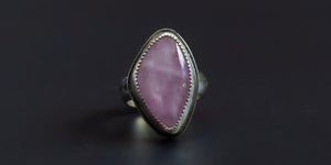 Handmade sterling silver ring with a natural shaped, pink, kunzite stone set in a serrated bezel and a hand-stamped ring shank