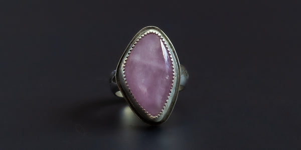 Handmade sterling silver ring with a natural shaped, pink, kunzite stone set in a serrated bezel and a hand-stamped ring shank
