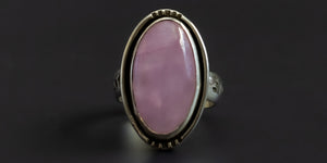 Handmade sterling silver ring with an oval shaped, pink, kunzite stone set in a plain bezel and a hand-stamped ring shank