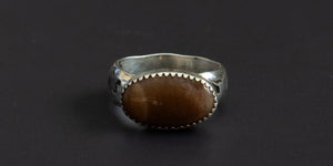 Oval sunstone set in a sterling silver handmade ring with a hand stamped ring band