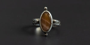Oval sunstone set in a sterling silver handmade ring with some silver ball embellishments and a hand stamped ring band